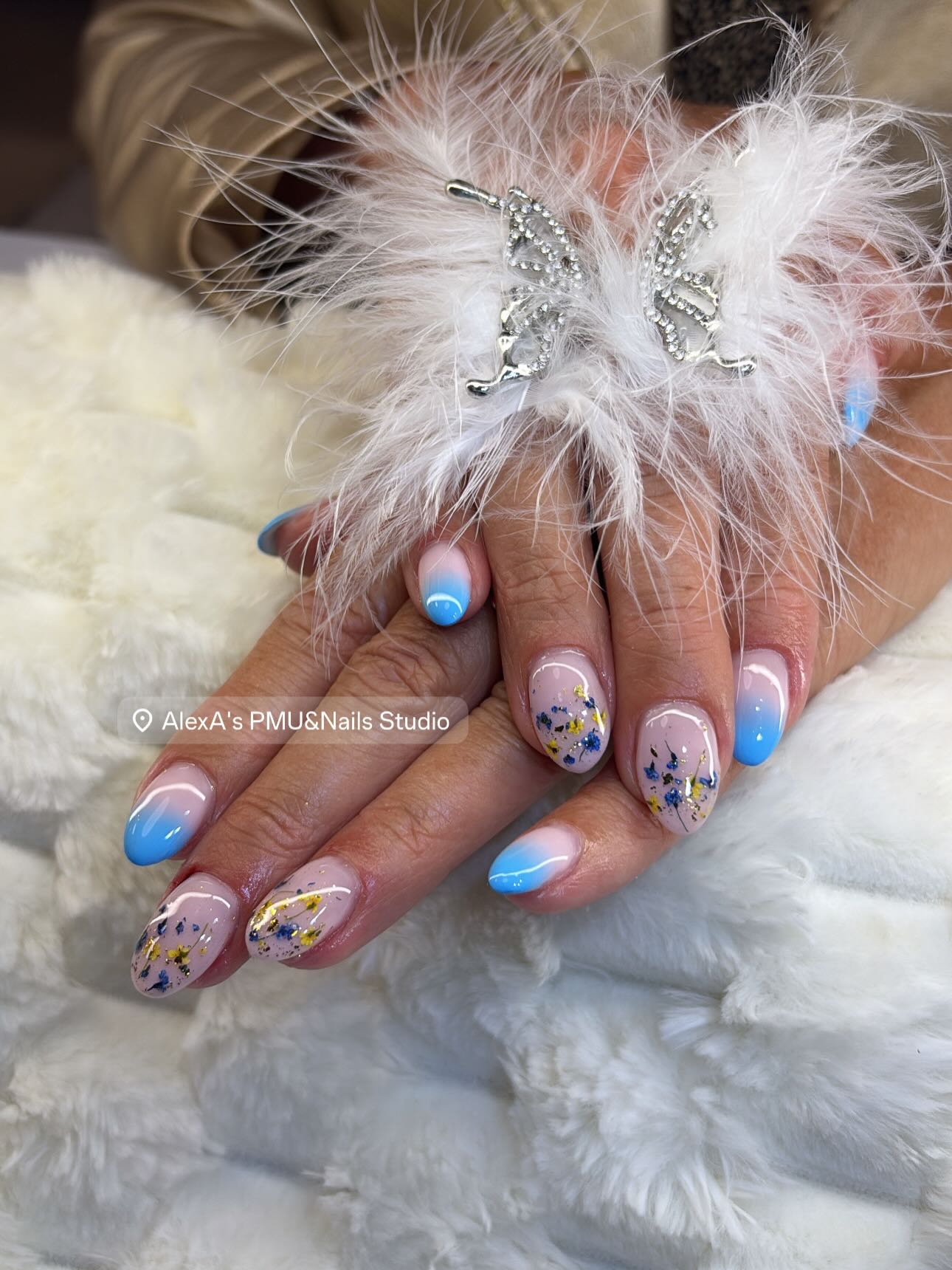Nailart met blauwe tips en gekleurde spikkels